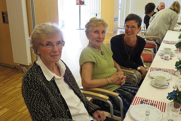 Drei Damen sitzen mit Kaffee bei Tisch