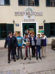 Eine Gruppe Jugendlicher mit Eltern stehen vor der Waldschule