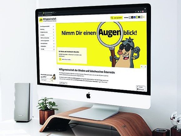 Auf einem Bildschirm ist die neue Website der Hilfsgemeinschaft mitsamt unserem Maulwurf-Maskottchen AUGust zu sehen