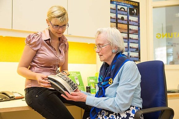 Junge Frau berät altere Dame beim Kauf eines Telefons