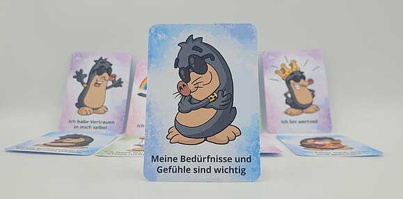 Foto von bunten Karten, im Vordergrund eine Karte da steht "Meine Gefühle und Bedürfnisse sind wichtig" oben