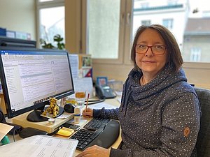 Gabriele Frisch sitzt an ihrem Arbeitsplatz im Büro vor dem Computer.