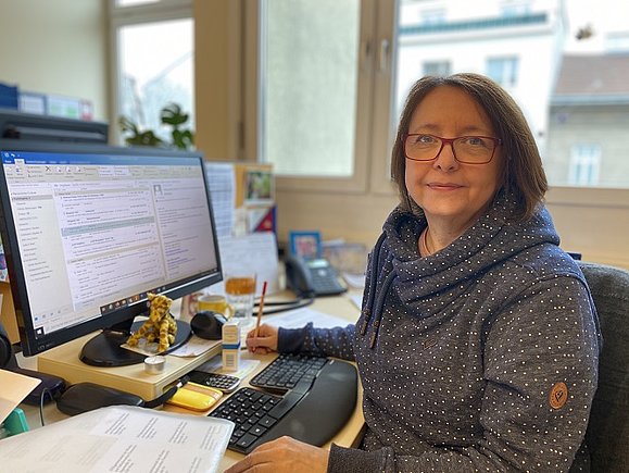 Gabriele Frisch sitzt an ihrem Arbeitsplatz im Büro vor dem Computer.