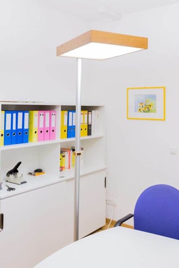 Blendfreie Stehleuchte mit hölzernem Rahmen und einem Metallbein