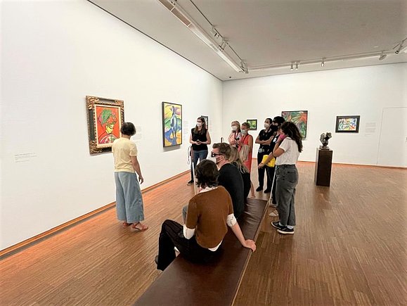 Reiter_Schulungen_barrierefreie_Kunstvermittlung Menschengruppe teils mit Langstock vor Gemälden im Museum