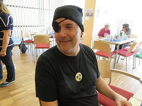 Freiwilliger Harry als Pirat Mann trägt schwarze Mütze, Augenklappe und ein schwarzes Shirt. Zusätzlich hat er eine aufgemalte Narbe im Gesicht