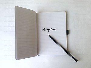 Ein Stift liegt auf einem Notizbuch mit dem Wort Akzeptanz 