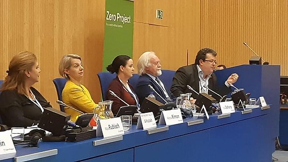 Klaus Höckner beim Policy Maker Forum der Zero Project Conference Zwei Männer und drei Frauen sitzen vor Mirkrofonen