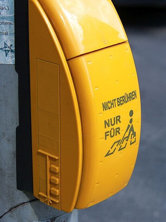 Ampelanlage mit Blindenakustik. Mit Aufschrift "Nicht Berühren, nur für" und Piktogramm eines Menschen mit Taststock