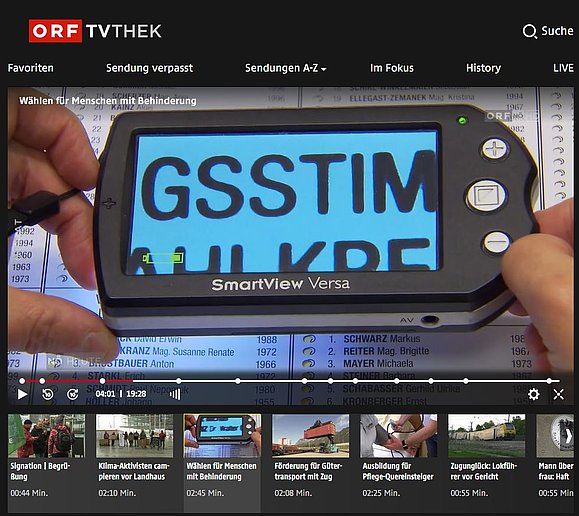 Screenshot ORF TVthek Beitrag Wählen für Menschen mit Behinderung: Nahaufnahme einer elektronischen Lupe zur Vergrößerung der darunterliegenden Wahlschablone