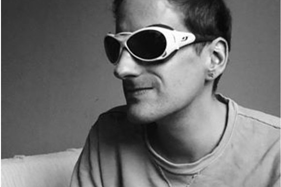 Ein Schwarz-Weiß Foto von einem Mann mit Brille.