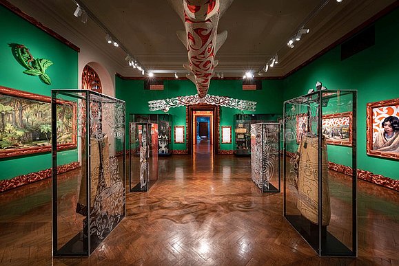 Ausstellungsraum mit grünen Wänden und orientalischen Skulpturen