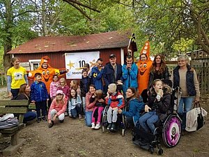 Gruppenfoto mit Kindern, Eltern, Gruppenleiterin und zwei lebensgroßen Maskottchen Sofie Sehsternchen