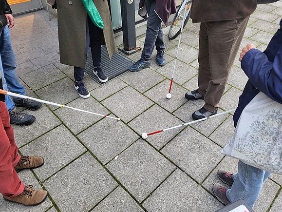 mehrere weiße Stöcke im Kreis treffen aufeinander