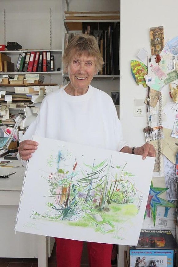 Lucia Kellner hält eine Pastellzeichnung mit Pflanzen in die Kamera