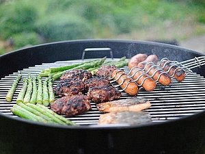 Griller belegt mit Würstchen, Spargel und Fleischlaibchen