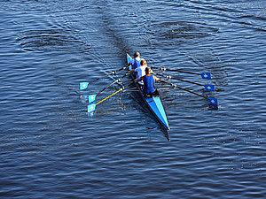 Ein Ruderboot mit drei Insassen auf dem Wasser.